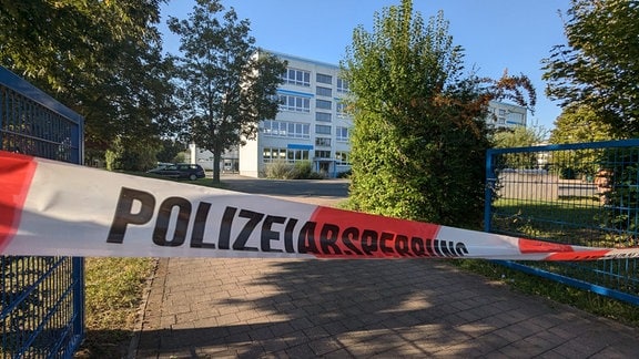 Eine Schule, vor der Absperrband der Polizei zu sehen ist