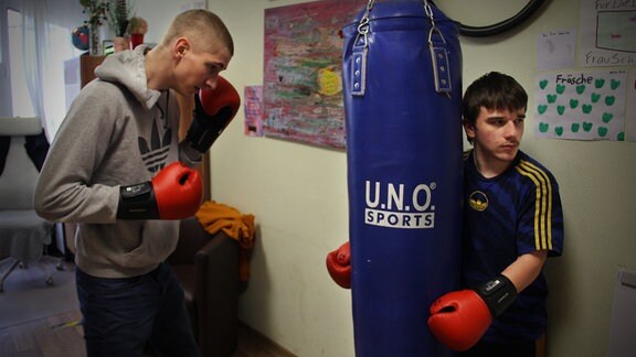 Schüler boxen gegen einen Boxsack.
