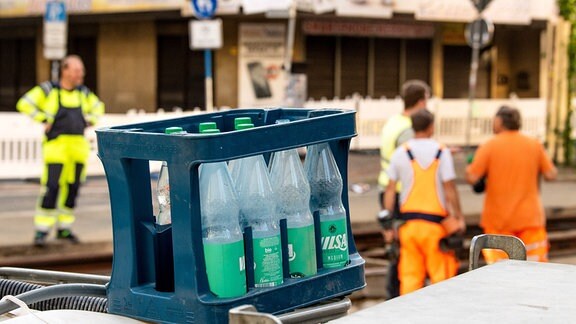Ein Kasten mit Wasserflaschen steht auf einer Baustelle