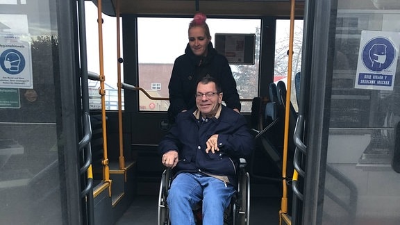 Franziska Moratschke schiebt Marcus Graubner im Rollstuhl über eine Rampe aus einem Bus