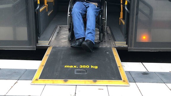 Franziska Moratschke schiebt Marcus Graubner im Rollstuhl über eine Rampe aus einem Bus