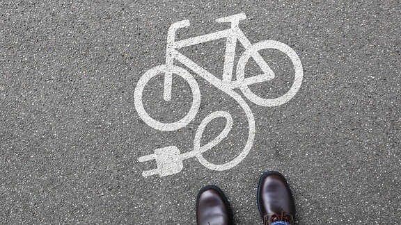 Symbol für ein E-Bike auf die Straße gezeichnet