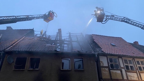 Die Feuerwehr löscht ein ausgebranntes Haus in der Innenstadt von Werben.