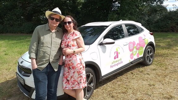 Reinhard Seehafer mit Ehefrau Carmen vor einem Auto der Altmark Festspiele.