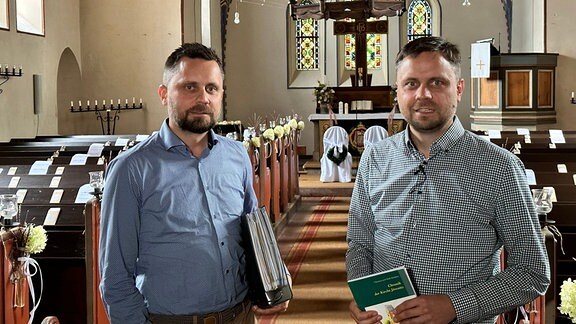 Zwei Männer stehen in einer Kirche