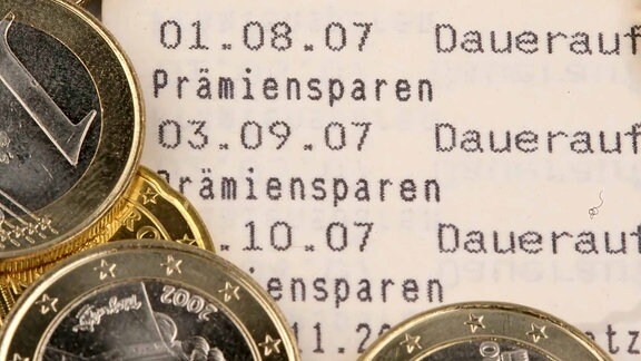 Euromünzen auf einem Sparbuch mit dem Schriftzug - Lösungswort.