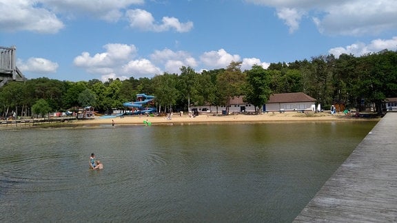 Blick von einem hölzernen Bootsstreg auf ein Strandbad