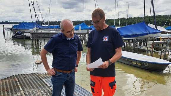 Norman Klebe, Bürgermeister von Arendsee, und Ulf Sachse, Leiter der Wasserwacht Salzwedel, stehen am Ufer des Arendsees.