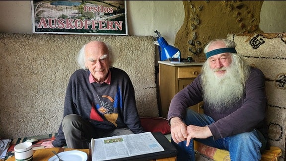 Christfried Lenz und Karl-Heinz Friedrichs sitzen an einem flachen Tisch.