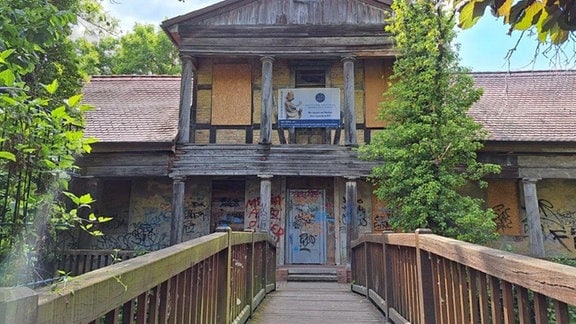 Historisches Badehaus Salzwedel: Holzbau mit gelber Fassade, davor eine Brücke