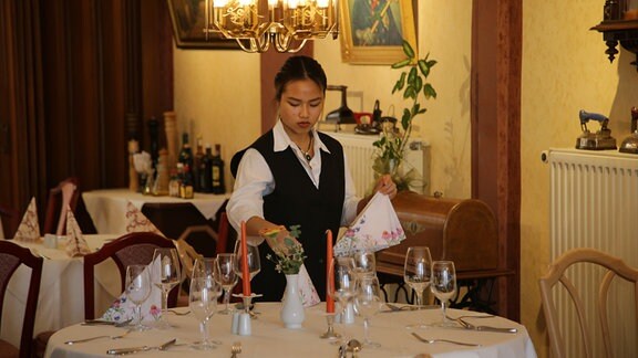 Ngoc Anh Hoang deckt den Tisch ein für die  Hotelgäste.