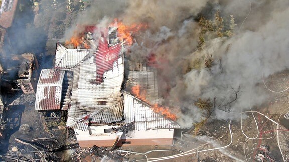 Blick von oben auf ein Einfamilienhaus in Flammen