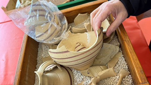 Keramikstücke in einer Sandkiste