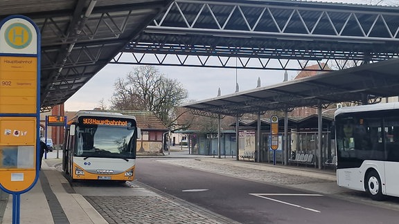 Zwei Busse in einem Busbahnhof.