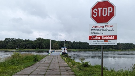 Ein Stop-Schild und ein "Auerßer Betrieb"-Hinweisschild am Fährableger in Arneburg