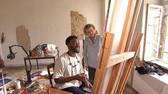 Ein Mann malt ein Bild in einem Atelier