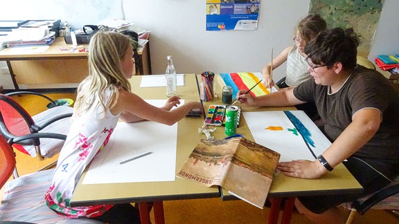 Drei Kinder malen Bilder