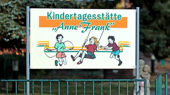 Schild zeigt drei gezeichnete spielende Kinder mit der Aufschrift "Kindertagesstätte Anne Frank"