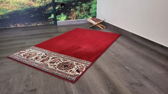 Ein Gebetsteppich liegt auf dem Boden
