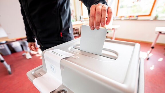 Ein Wähler wirft seinen Wahlschein in die Urne im Wahlraum