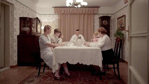 Familie Höß mit Sandra Hüller (l) als Hedwig Höß und Christian Friedel (M) als Rudolf Heß sitzt am Esstisch in einer Szene des Films "The Zone of Interest"