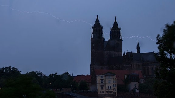 Ein Blitz entlädt sich am Abend über dem Magdeburger Dom.