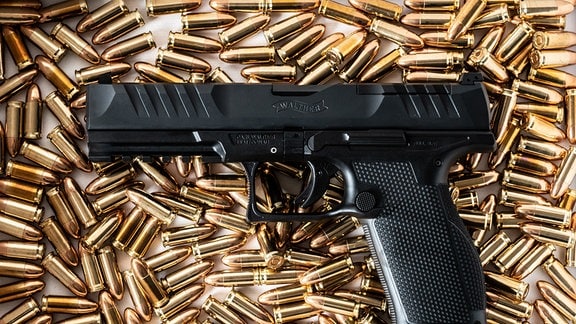 Eine Walther PDP Full Size 5“ Pistole und 9mm Patronen liegen auf einem Tisch eines Sportschützen. 