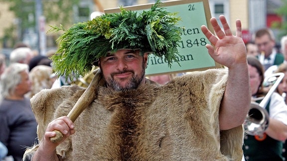Ein als "Wildemann" (Sage der Bergstadt Wildemann) verkleideter Teilnehmer posiert in Clausthal-Zellerfeld beim Festumzug zum Harzfest.