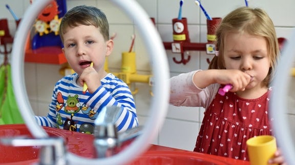 Kinder putzen sich ihre Zähne nach dem Mittagessen.
