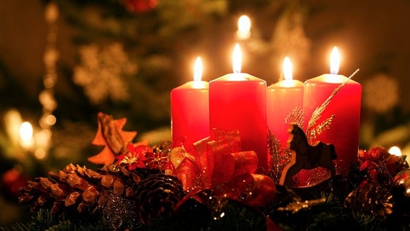 Vier rote Kerzen brennen auf einem Adventskranz
