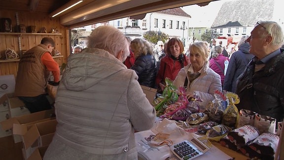 Menschen an einem Verkaufshäusschen auf dem Pfefferkuchenmarkt