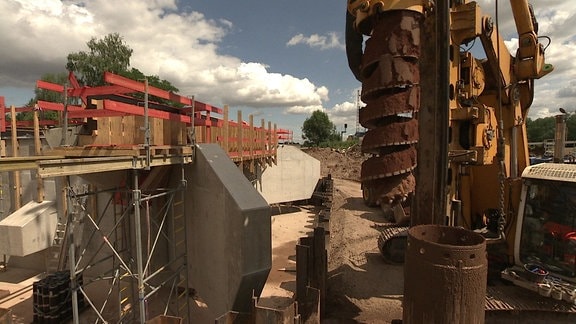 Ein Erdbohrer an einer Bahnbrücke.