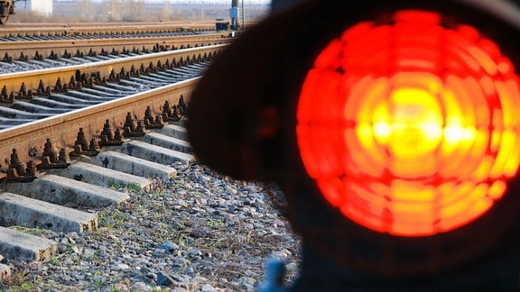 An einer Bahnstrecke leuchtet ein rotes Haltesignal auf.