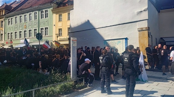 Rechte Gegendemonstranten stehen am Kornmarkt von Bautzen.