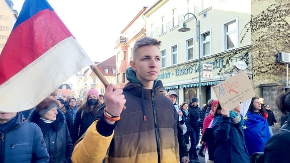 Ein junger Mann hält eine Fahne.