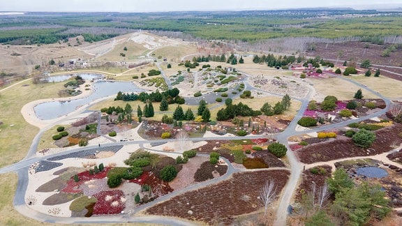 Besucher gehen im Findlingspark Nochten durch den angelegten Garten