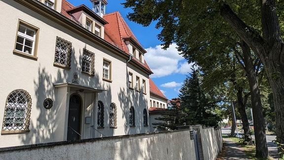 Ein historisches Gebäude steht hinter einer Mauer.