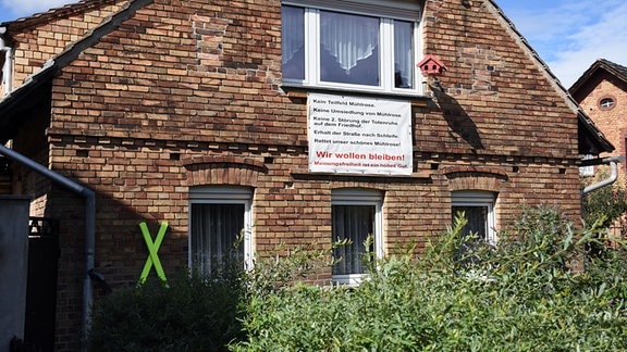 Backstein-Abrisshaus mit Schild "Wir wollen bleiben" - Mühlrose