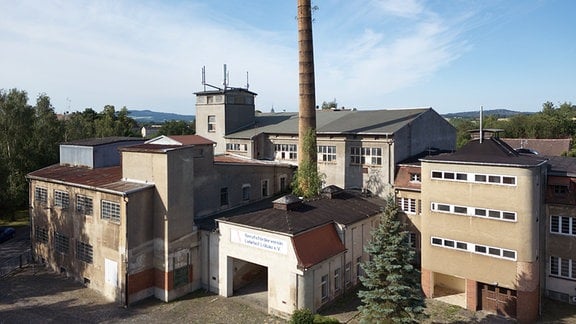 Blick auf ein Fabrikgebäude umringt von Häusern
