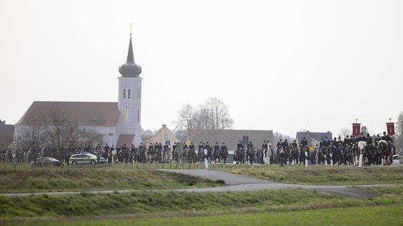 Eine lange Prozession von Reitern mit Zylindern 