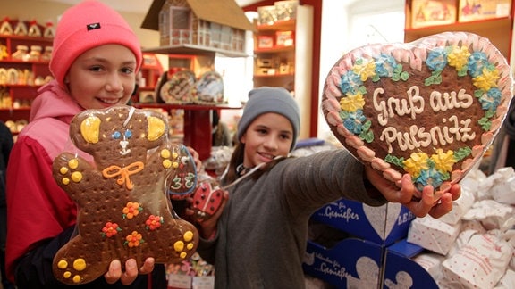 Zwei Mädchen präsentieren Pfefferkuchengebäck für die Kamera.