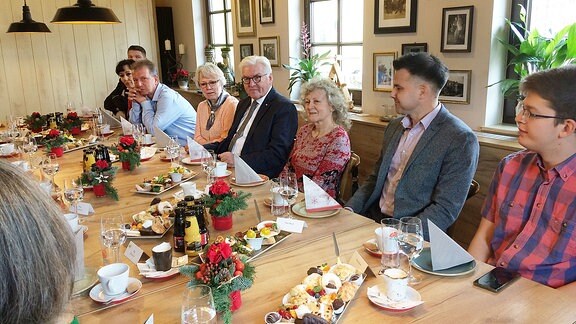 Bundespräsident Steinmeier sitzt in Pulsnitz mit Menschen an einer Kaffeetafel.