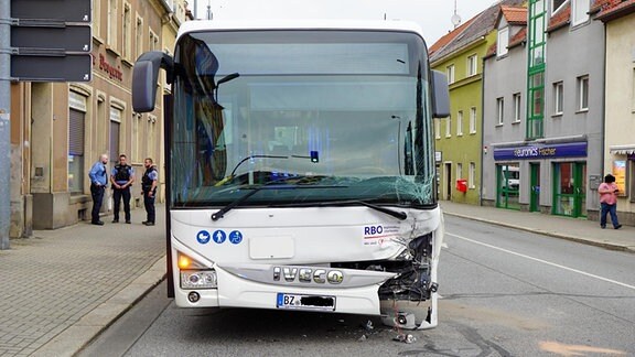 Ein beschädigter Bus steht auf einer Straße mitten in Kamenz