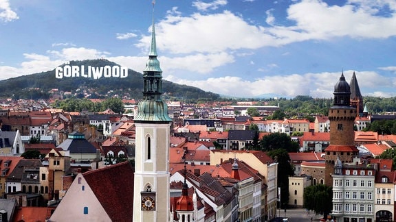 Eine Bildmontage zeigt die Stadt Görlitz und den Schriftzug Görliwood an einem Berghang dahinter