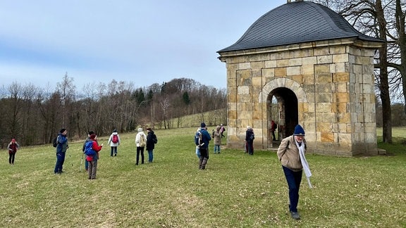 Wanderer stehen an der kleinen Dreifaltigkeitskapelle nahe dem tschechsischen Mikulášovice.