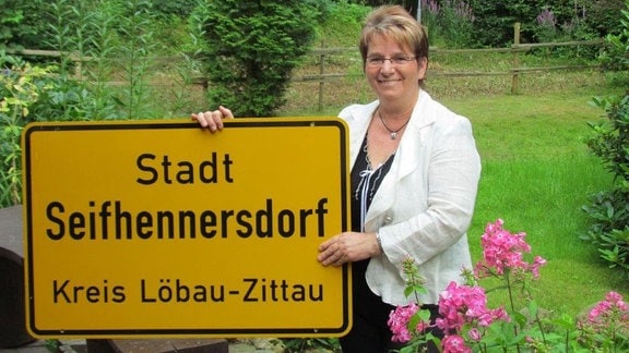 Bürgermeisterin mit Ortsschild Seifhennersdorf