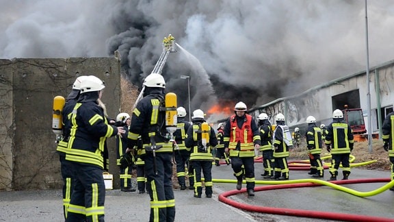 Feuerwehrleute bei Löscharbeiten von Großbrand in Kunststofffabrik in Niedercunnersdorf