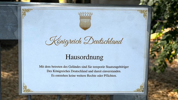 Ein Schild weist auf die Hausordnung im Königreich Deutschland hin