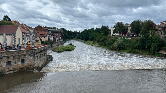 Ein großes Wehr über das Wasser hinwegfließt.