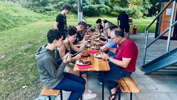 Gruppe Menschen essen gemeinsam an einem Tisch